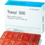 সাদা রঙের Traxyl 500 ক্যাপসুল যা রক্তপাত কমাতে ব্যবহৃত হয়। পটভূমিতে একজন ডাক্তার প্রেসক্রিপশন লিখছেন, যা এই ঔষধটির চিকিৎসার ক্ষেত্রে ব্যবহারের ইঙ্গিত দেয়।